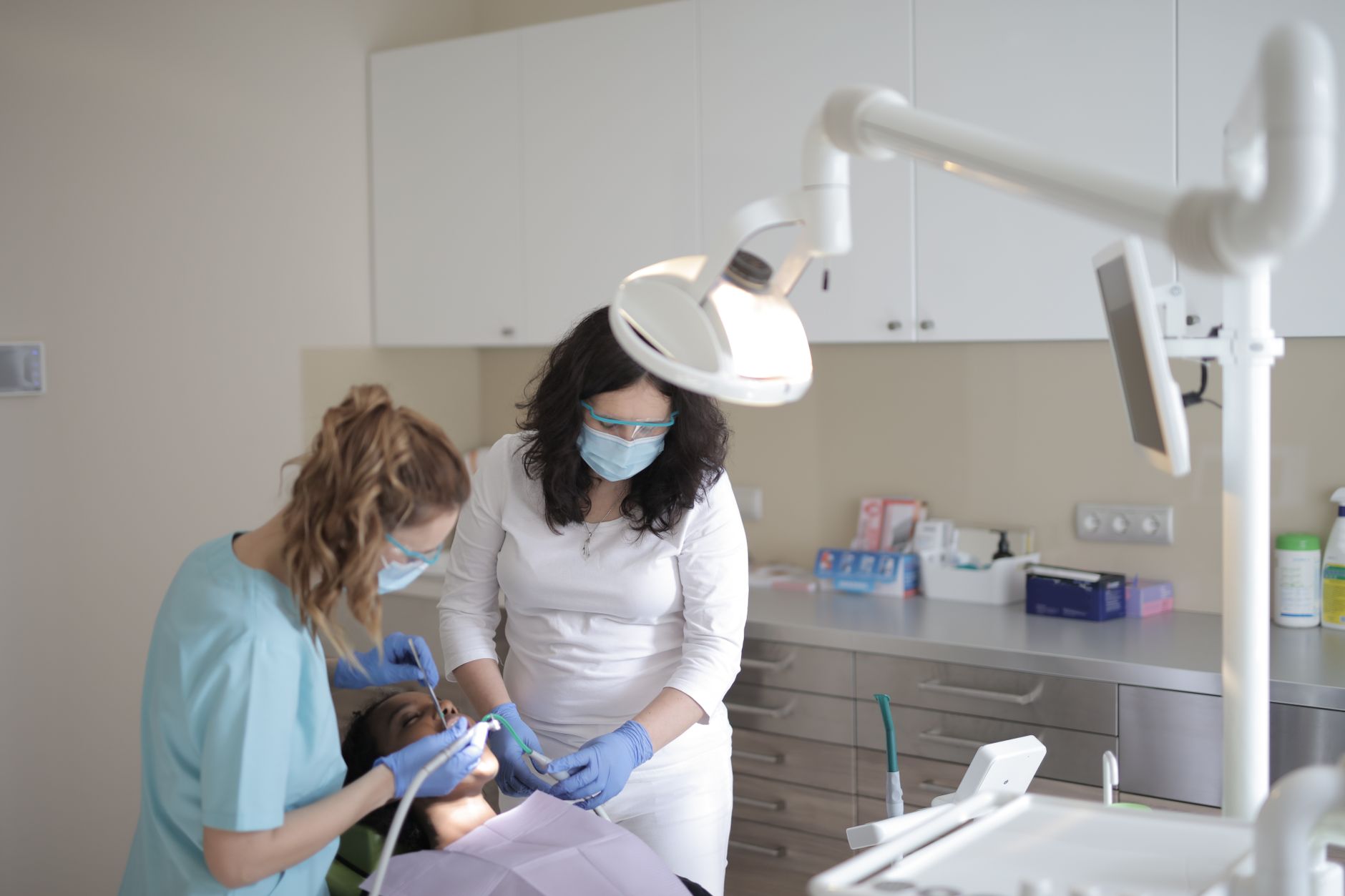 Dental assistant helping a dentist treat a patient in a modern clinic