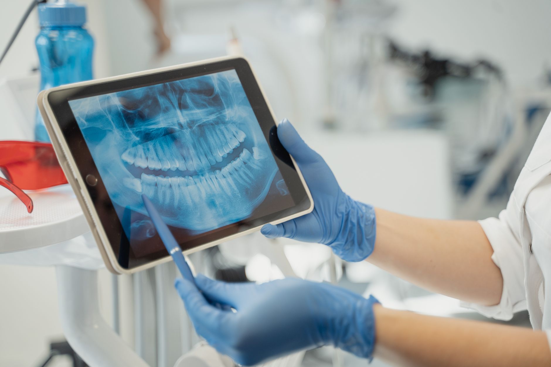 Dental professional reviewing a digital x-ray on a tablet